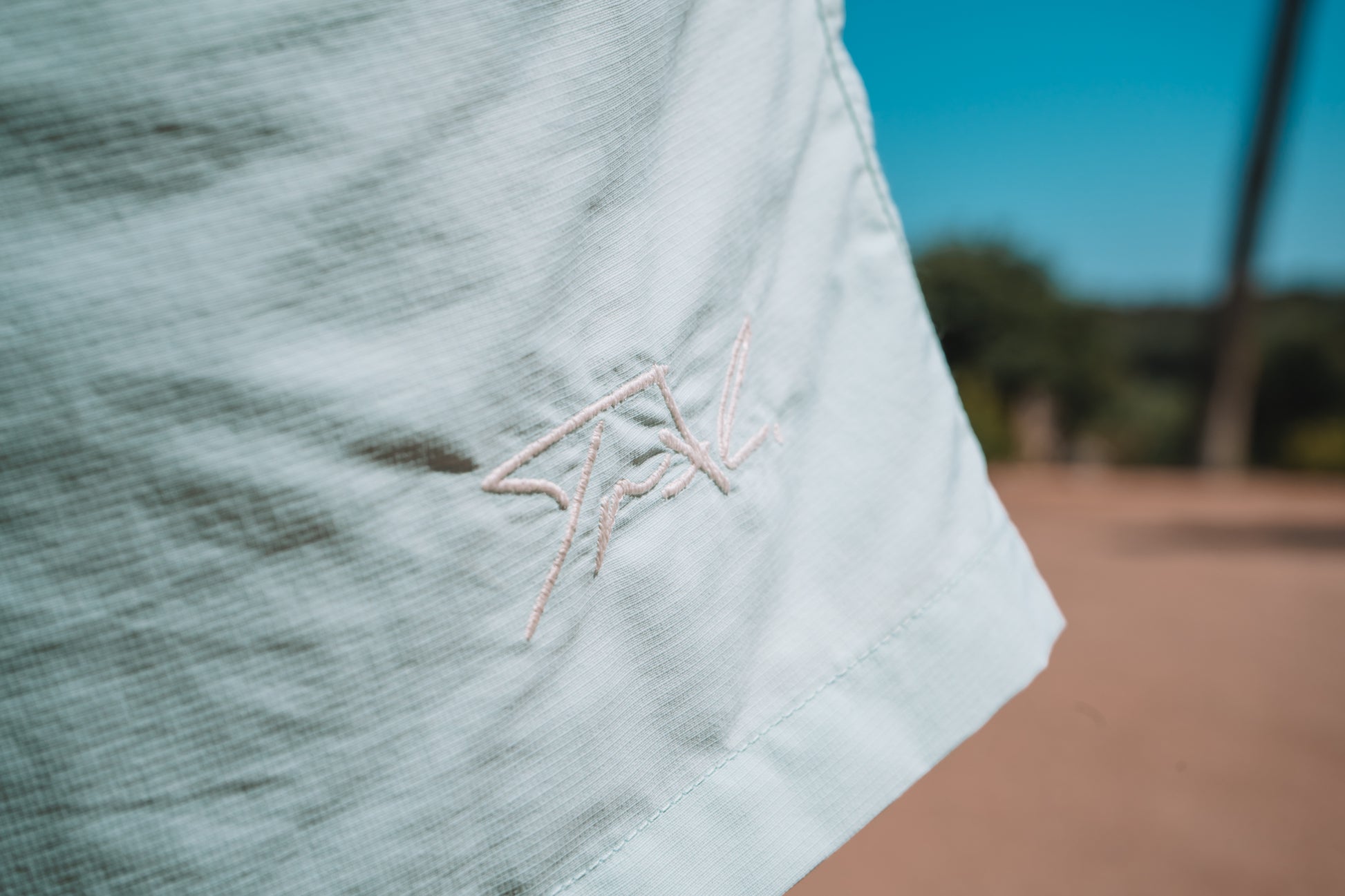 Broderie blanche sur short de bain pour homme.
